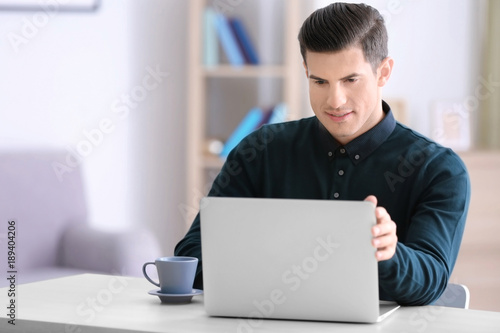 Young man using laptop at t...