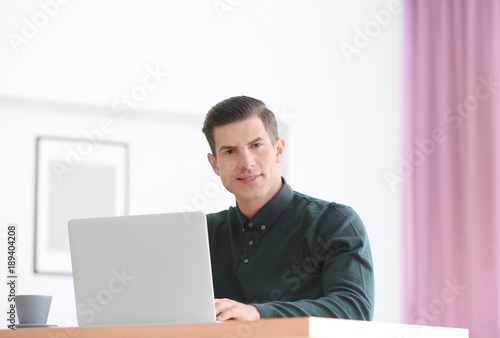 Young man using laptop at t...