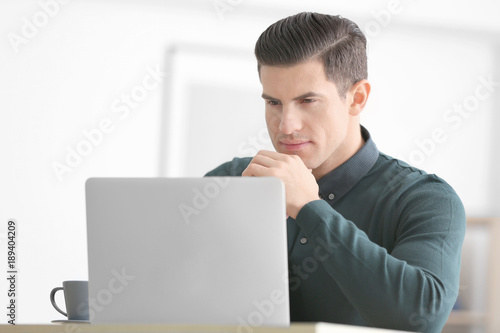 Young man using laptop at t...