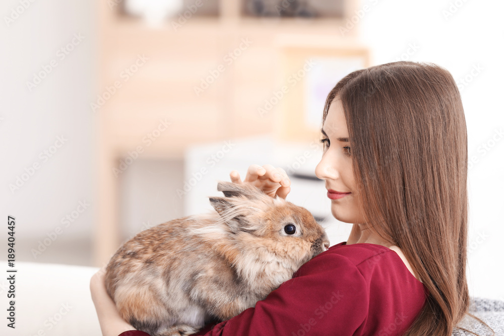 Beautiful young woman with pet rabbit at home Beautiful young woman with pet rabbit at home