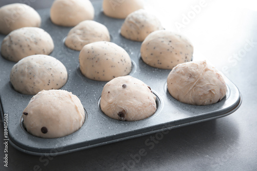 Raw dough in muffin tin on table