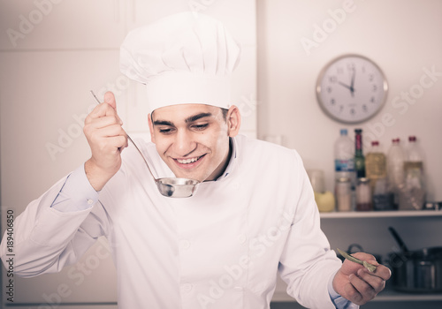 Young man is degustating soup photo