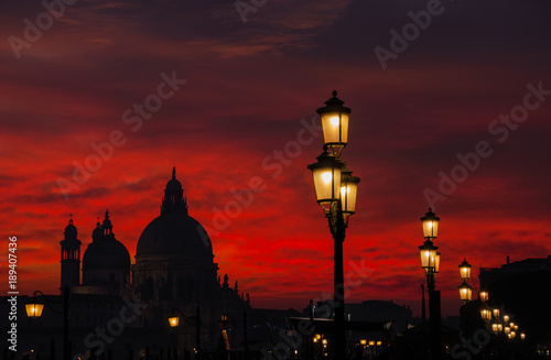 Venice red blood sky sunset with Salute Basilica domes and lamps