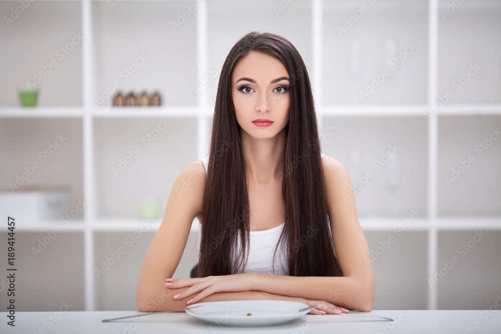 Diet. Woman sitting at a table with vegetables on a plate Diet. Woman sitting at a table with vegetables on a plate