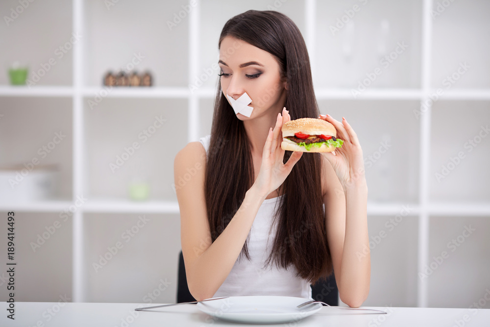 Diet. Close up face of young beautiful sad latin woman with mouth sealed on stick tape Diet. Close up face of young beautiful sad latin woman with mouth sealed on stick tape