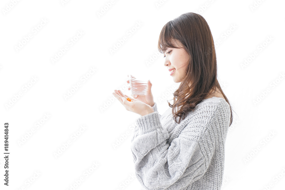 錠剤・サプリメントを飲む女性 錠剤・サプリメントを飲む女性