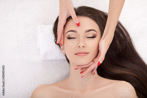 Woman under professional facial massage in beauty spa photo