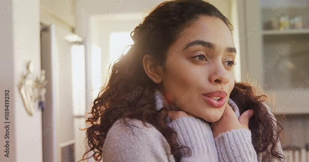 Woman wearing winter cloths standing in kitchen feeling cold Woman wearing winter cloths standing in kitchen feeling cold