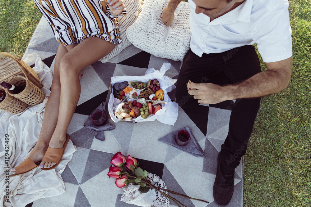 Romantic couple having a picnic at sunset