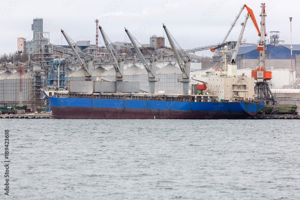 Fototapeta premium Vessel dry cargo on loading, unloading in port. Bulker in port.
