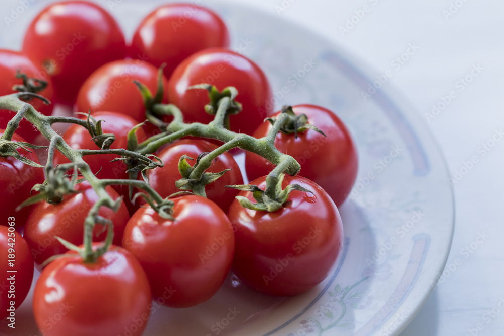 Stoning high-angle shot of some tiny cute tomatoes in a plate. Close-up picture. Stoning high-angle shot of some tiny cute tomatoes in a plate. Close-up picture.