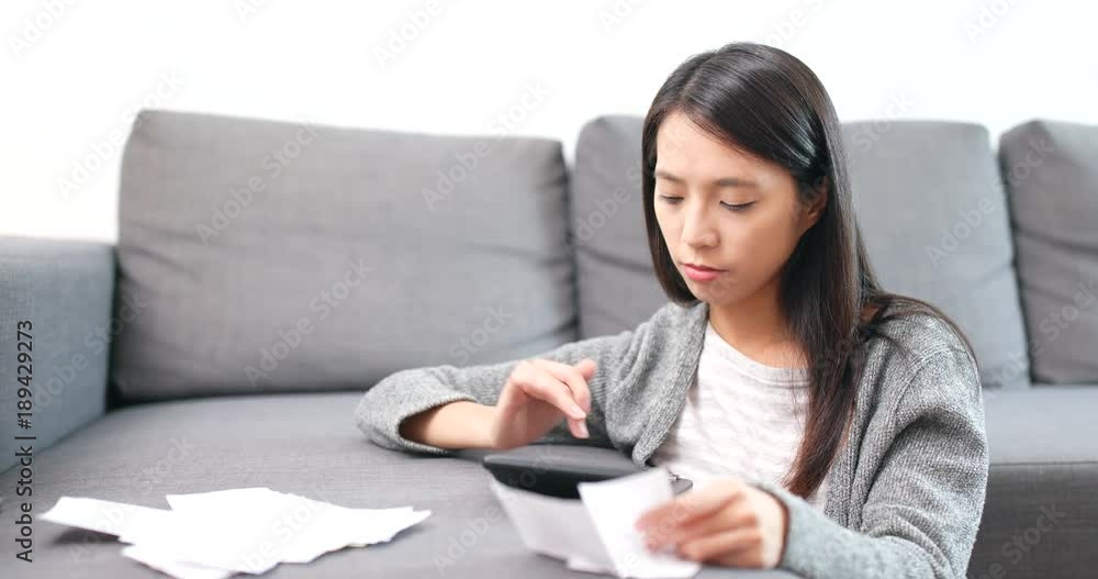 Woman counting expense with calculator Woman counting expense with calculator