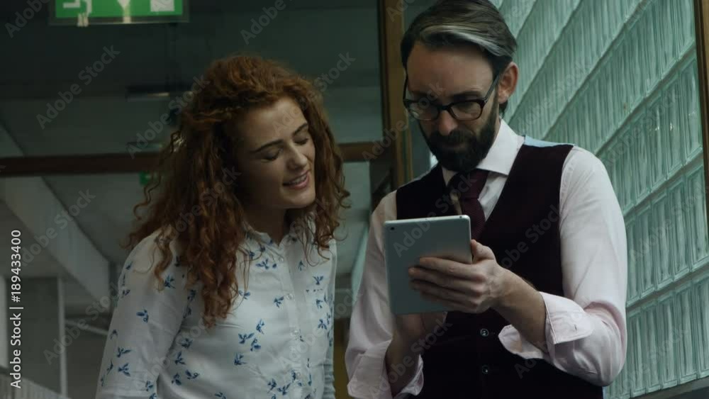 Colleagues discussing over digital tablet Colleagues discussing over digital tablet