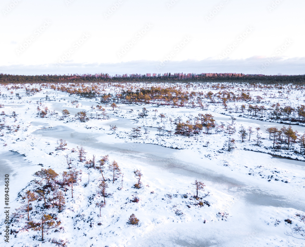 Aerial view of a cold and snowy winter morning sunrise in Enda bog. Enda, Estonia. Aerial view of a cold and snowy winter morning sunrise in Enda bog. Enda, Estonia.