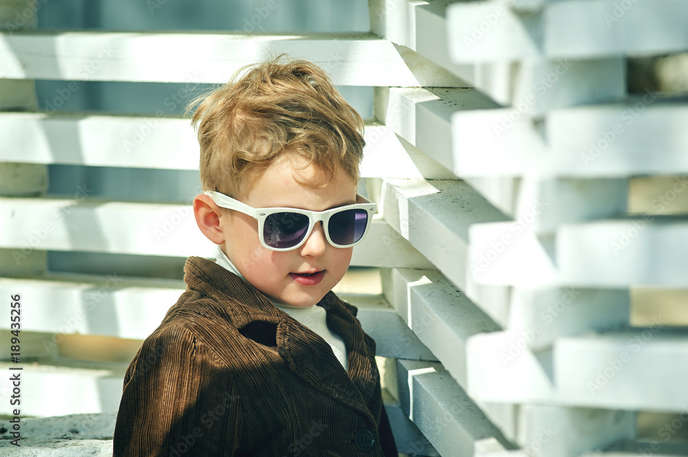 beautiful fashion boy in sunglasses in the city