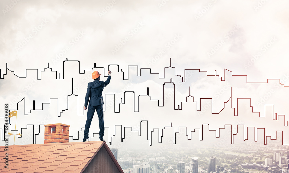 Man architect draw silhouette of modern city on blue sky. Mixed 