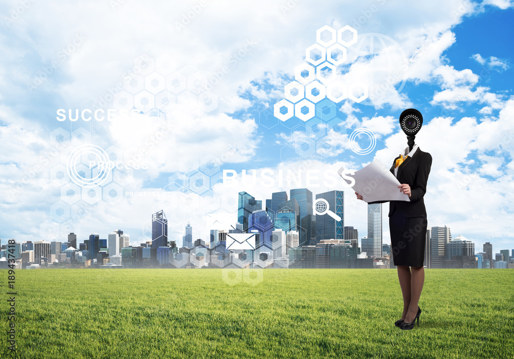 Camera headed woman standing on green grass against modern cityscape Camera headed woman standing on green grass against modern cityscape