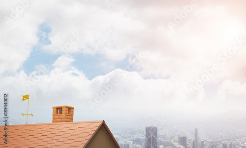 Brick house roof and modern cityscape at background