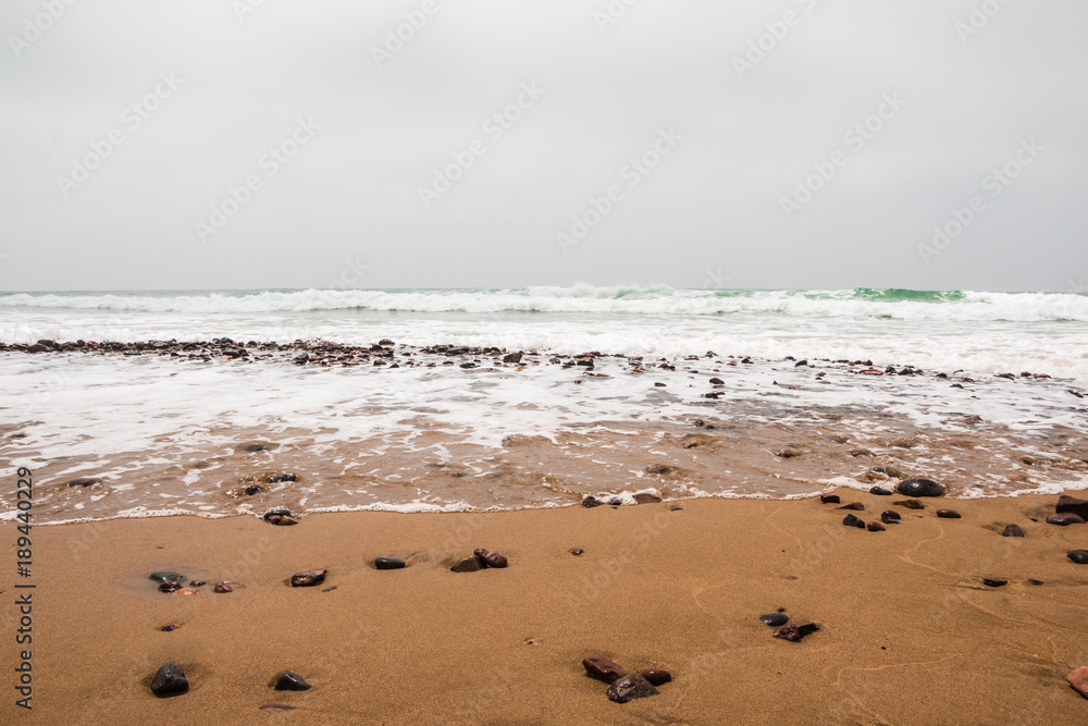 Coast, waves and beach with yellow sand and pebbles Coast, waves and beach with yellow sand and pebbles
