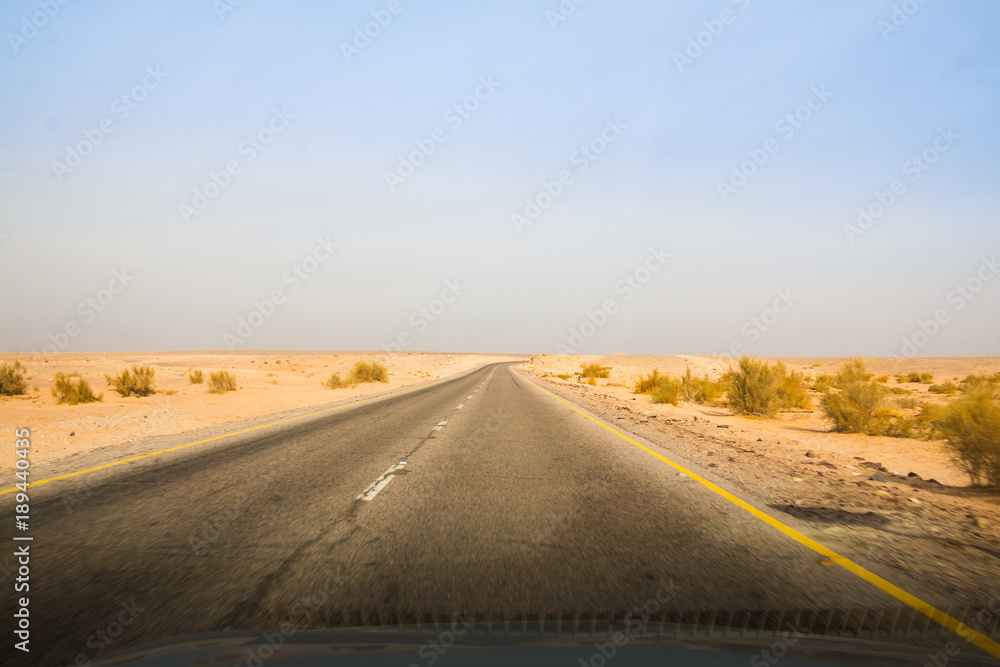 Desert highway and mountains through car window not far from Dead sea Desert highway and mountains through car window not far from Dead sea