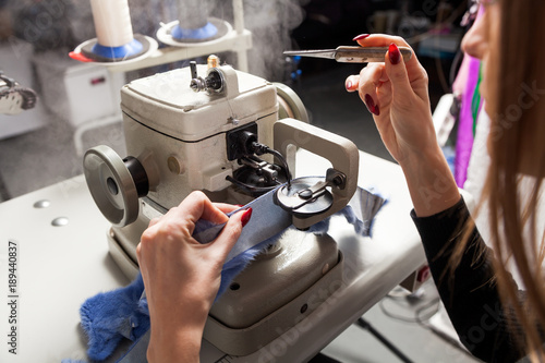 Close-up of a woman furrier working on a furrier's sewing machine to treat fur and skin