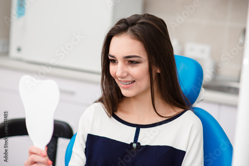 Happy woman with braces smiling in dentistry. photo