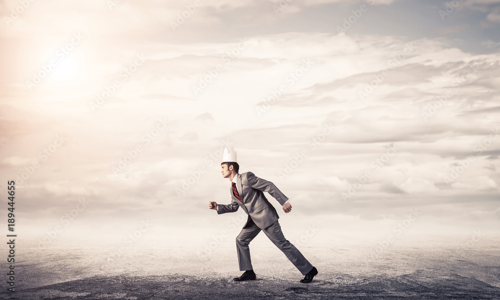 King businessman in elegant suit running and blue sky at backgro