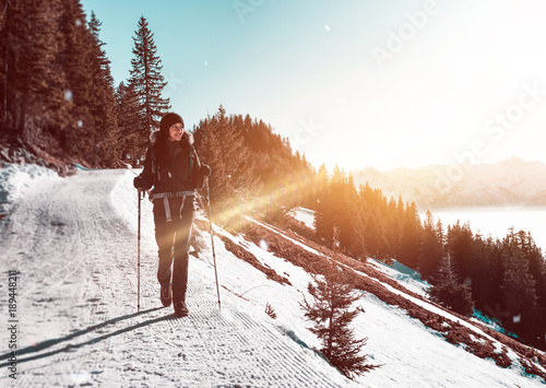 Woman hiking along trail in snowy mountains