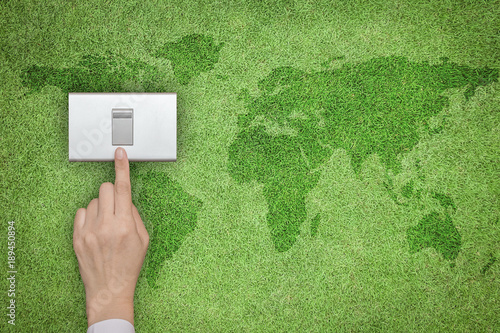 Fotografija Energy saving and ecological friendly concept with hand turning off switch on gr