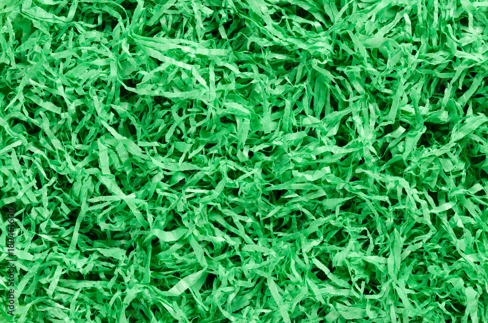 Green paper Easter grass background from above. Colored crinkle grass. Gift basket shred and filler. Decoration. Green paper Easter grass background from above. Colored crinkle grass. Gift basket shred and filler. Decoration.