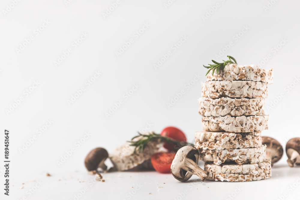 stack of rice cakes with mushrooms and tomatoes on white surface stack of rice cakes with mushrooms and tomatoes on white surface