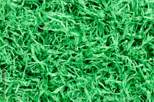 Green paper Easter grass background from above. Colored crinkle grass. Gift basket shred and filler. Decoration.