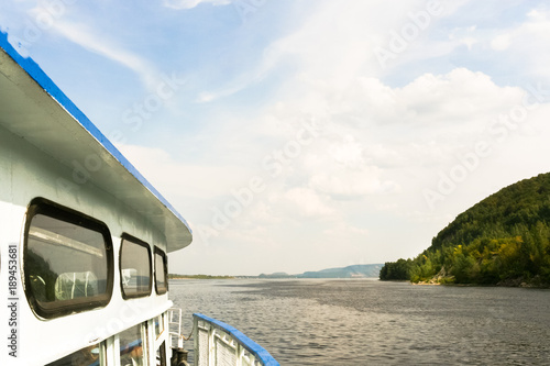 Part of steamer, floating on the Volga river and beautiful cloudy sky in summer day.