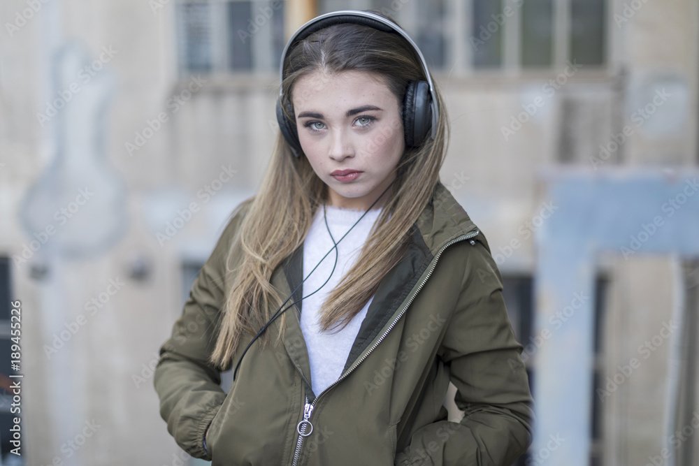 Young girl with headphones standing casual wearing