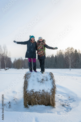 Two cheerful young women on a haystack.