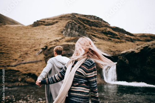 Iceland couple wearing Icelandic sweaters in beautiful nature landscape on Iceland. Woman and man model in typical Icelandic sweater.