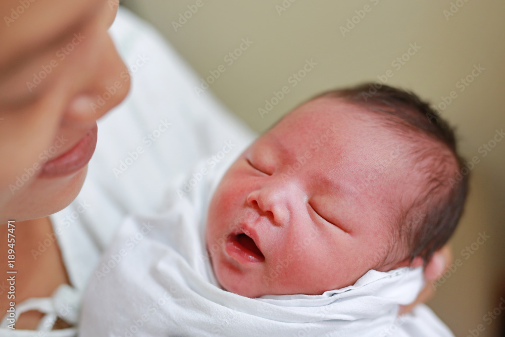 Asian mother carrying her baby on her breast. Asian mother carrying her baby on her breast.