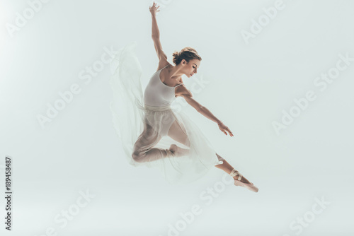 Φωτογραφία beautiful ballet dancer in white dress jumping in studio, isolated on white