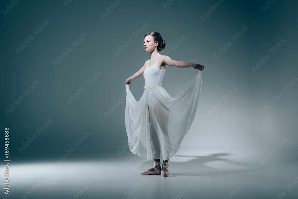 © LIGHTFIELD STUDIOS - elegant ballerina standing in white dress