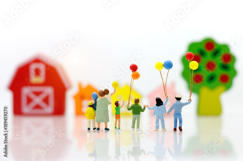 Miniature people with family holding balloon  with houses  happy family day concept.