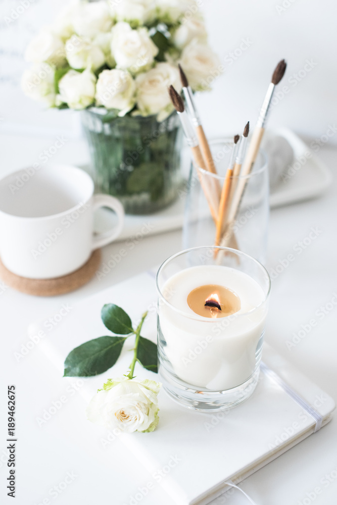 White room interior decor with burning hand-made candle and bouq White room interior decor with burning hand-made candle and bouq