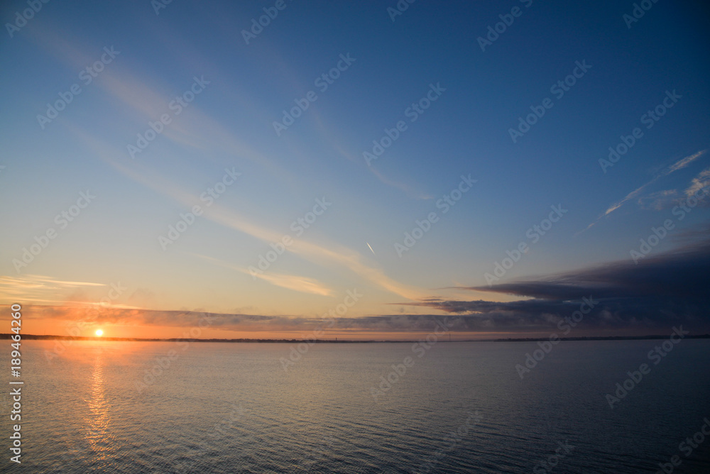 Golden, colorful, abstract sea sunrise view at horizon, vibrant sky landscape and small waves in the water