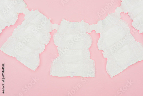 top view of clean unused baby diapers isolated on pink