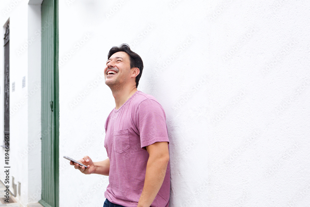 cheerful older man standing outdoors with mobile phone and smiling cheerful older man standing outdoors with mobile phone and smiling