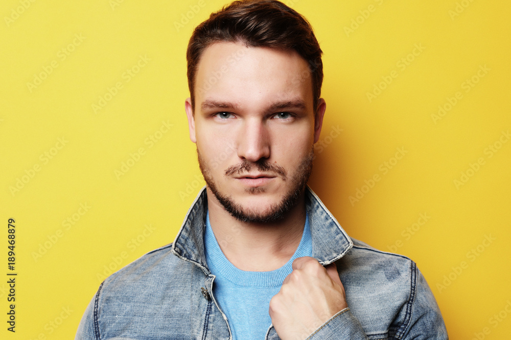 Fototapeta premium Picture of young man standing isolated over yellow background. L