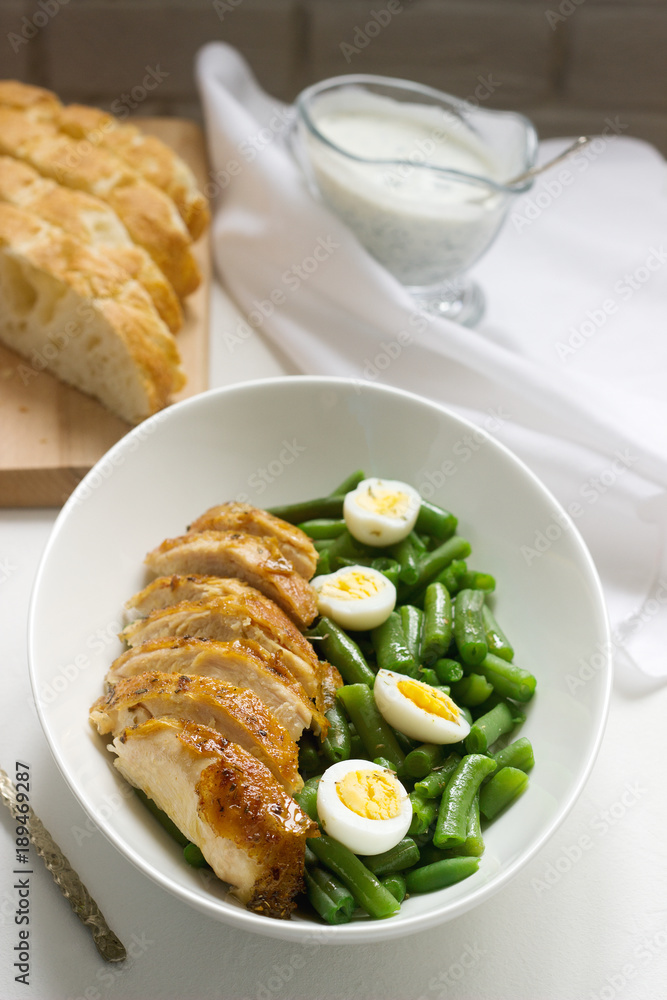 Roasted chicken breasts served with fried egg and boiled green beans. Roasted chicken breasts served with fried egg and boiled green beans.