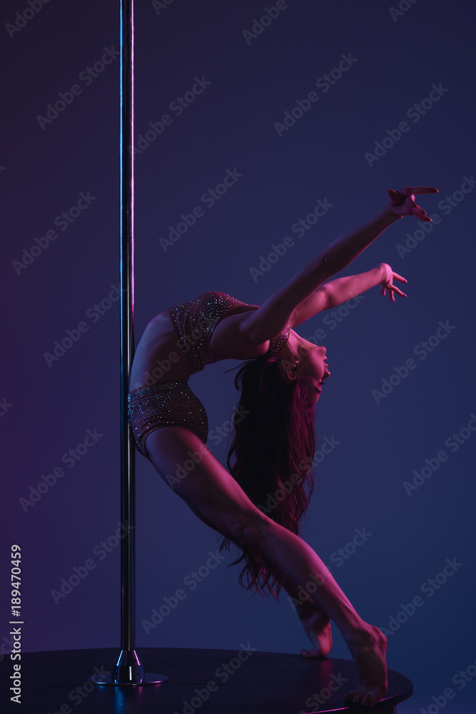 flexible athletic girl dancing with pole on blue flexible athletic girl dancing with pole on blue
