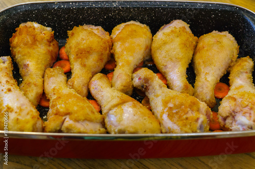 Chicken legs baked on the roasting pan in the oven. photo