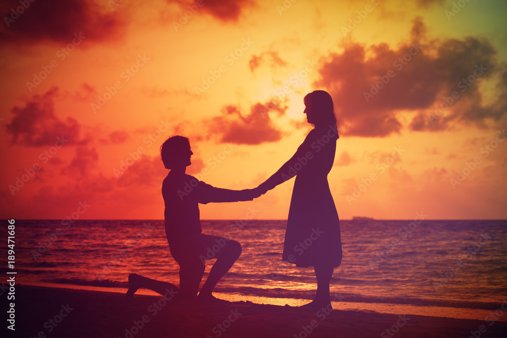 Silhouette of a young romantic couple at sunset beach