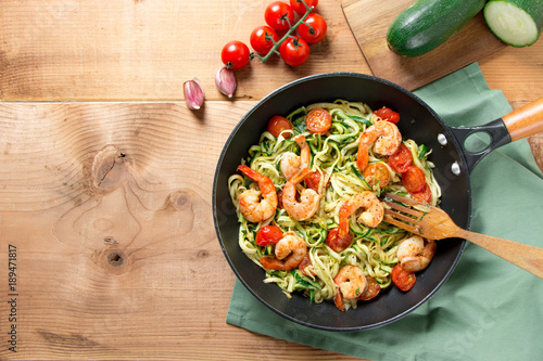 Zucchini noodles with cherry tomato and prawns in a pan